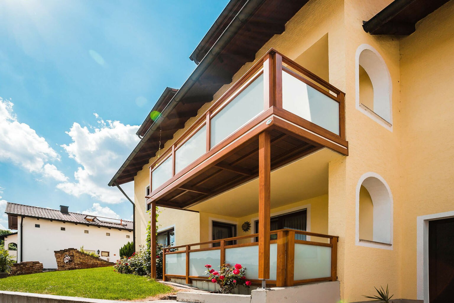 Orange Hausfassade mit Alu-Anbaubalkon