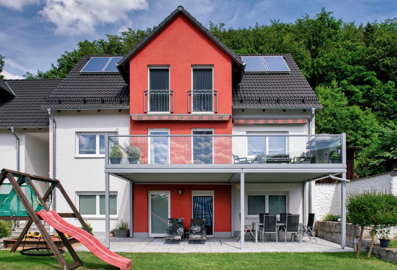 Spielplatz mit roter Rutsche und Alu Design Vital Balkongeländer