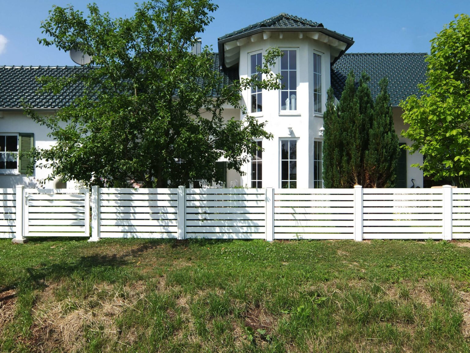 Weiße Villa mit Turm und Aluzaun Castillo